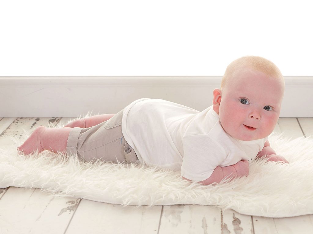 Little toddler sprawled out on a sheep skin rug