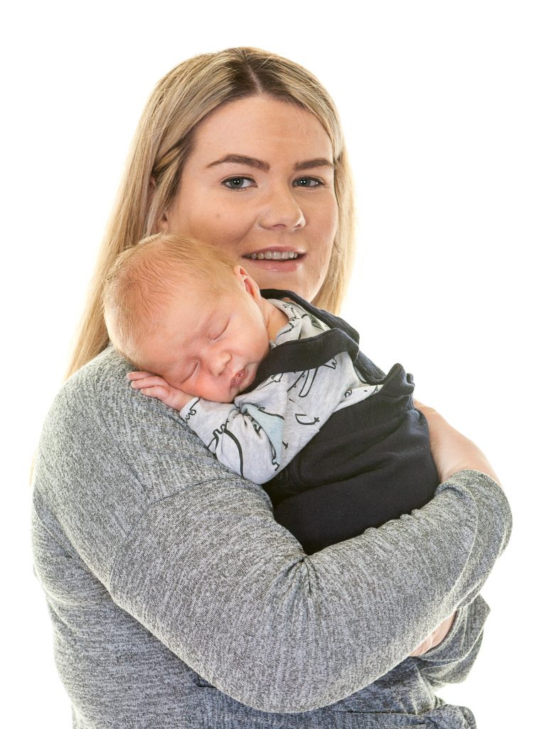 newborn baby boy sleeps on his mom's shoulder